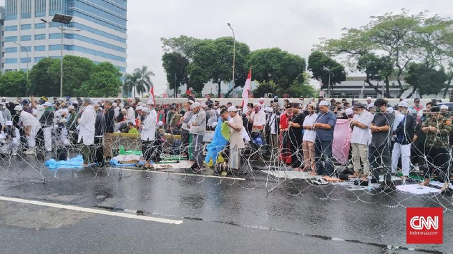 Massa pengunjuk rasa yang menolak Rancangan Undang-Undang Haluan Ideologi Pancasila (RUU HIP) menggelar salat Zuhur di sisi kiri pintu gerbang gedung MPR/DPR, Kamis (16/7) siang.