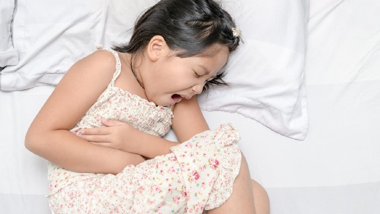 asian child suffering from stomachache and lying on bed. diarrhea or healthy concept