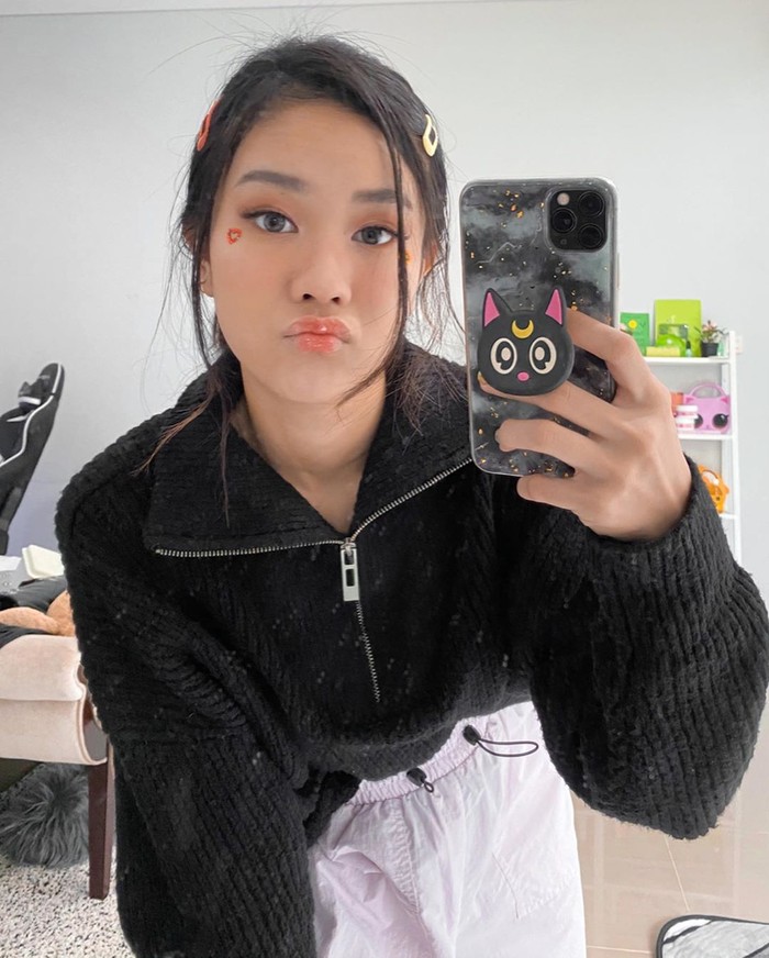 Dalam look pertamanya, Jessica Jane memadukan oversized sweater dan training pants. Meskipun warna outfit yang digunakan bernuansa monokrom, namun makeup peach dengan detail hiasan di ujung mata membuat look Jessica Jane lebih fun.