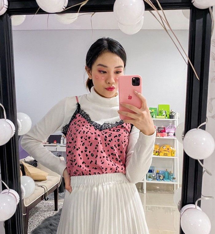 Kalau kamu punya turtle neck polos, coba deh padukan dengan tank top pattern berwarna cerah. Kamu juga bisa menggunakan pink makeup dengan detail hati yang super cute seperti Jessica Jane.