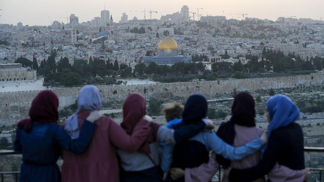 Palestinians gather to break their fast during the Muslim holy month of Ramadan, at the Mount of Olives with a backdrop of the Old City of Jerusalem and the closed al-Aqsa Mosque compound on May 19, 2020, during the novel coronavirus pandemic crisis. (Photo by Ahmad GHARABLI / AFP)