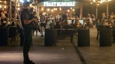 Mallorca, Pulau Pesta di Spanyol A Guardia Civil officer holds his weapons as tourists stand in a bar at the resort of Magaluf on the Spanish Balearic island of Mallorca, Spain, Thursday morning, July 16, 2020. Authorities in Spain's Balearic Islands are pulling the plug on endless drunken nights to the beat of techno music by closing bars and nightclubs in beachfront areas popular with young and foreign visitors. (AP Photo/Joan Mateu)