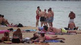 Mallorca, Pulau Pesta di Spanyol Tourists enjoy the beach at the Spanish Balearic island of Mallorca, Spain, Thursday, July 16, 2020. In a move designed to stop the spread of the new coronavirus and shake off the region's reputation as a party hub, regional authorities in the Balearic Islands ordered the closure from Thursday of all establishments along Mallorca's