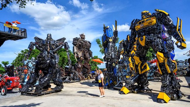 This photograph taken on July 18, 2020 shows tourists taking photos of life-sized sculptures of characters from the 