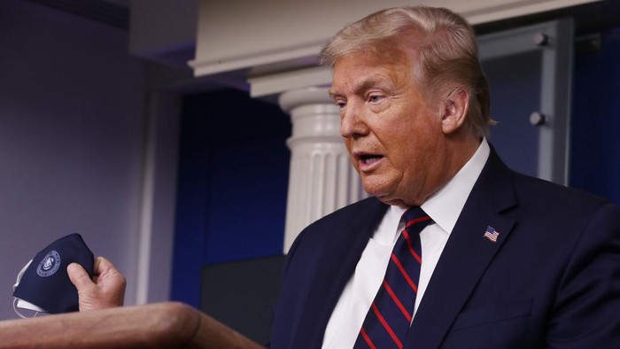 WASHINGTON, DC - JULY 21: U.S. President Donald Trump talks to holds up his face mask during a press conference in the Brady Press Briefing Room at the White House July 21, 2020 in Washington, DC. Trump focused on his administration's handling of the global coronavirus pandemic. Poll numbers about his handling of COVID-19 have been falling as cases of deadly virus have spiked across the country.   Chip Somodevilla/Getty Images/AFP