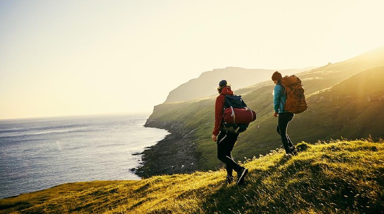 Ilustrasi traveling Shot of a young couple hiking through the mountains
