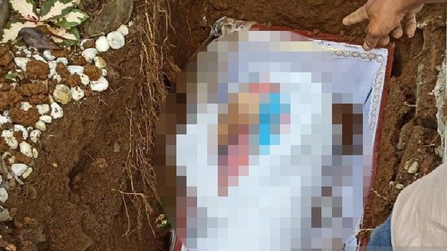 Saat peti dibongkar oleh keluarga karena tidak muat di liang kubur, tampak jenazah yang masih berdaster di TPU Suka Maju, Medan.
