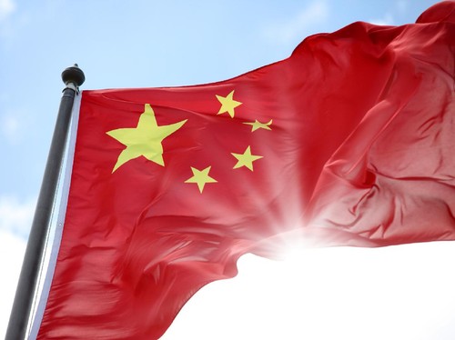 "China national flag, with sun beam shiny through."