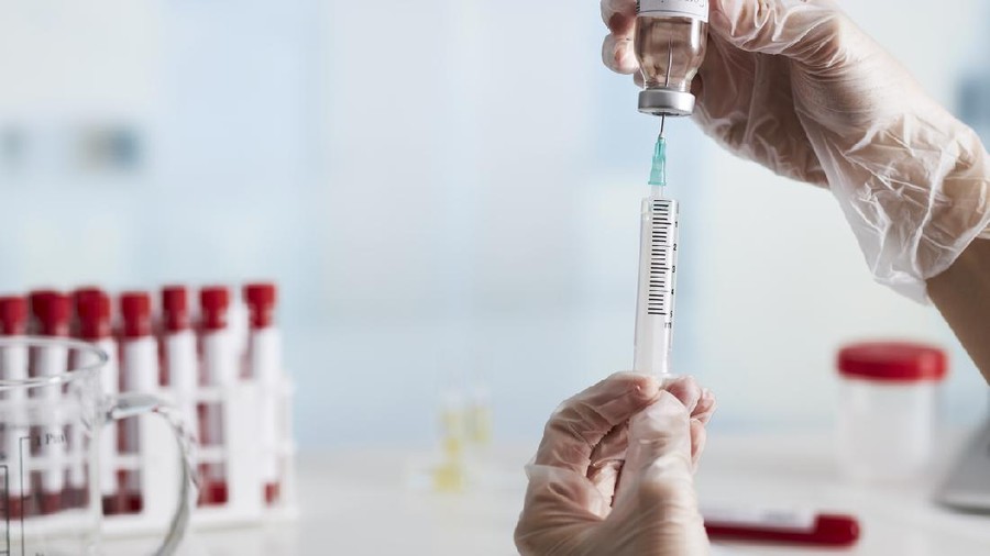 The doctor prepares the syringe with the cure for vaccination.