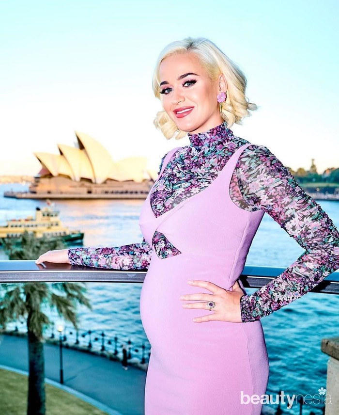 Dengan riasan makeup on point, Katy Perry berpose dengan latar belakang Sydney Opera House. Warna ungu mendominasi pakaian dan aksesori yang dikenakannya. Ia mengenakan dress polos berwarna ungu dengan dalaman blouse turtle neck motif bunga berwarna ungu. Demi menyempurnakan penampilannya, ia mengenakan anting bunga berwarna ungu serta rambut pendek blonde. (Foto: instagram.com/katyperry/)