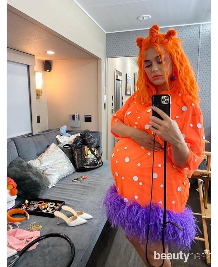 Katy Perry dikenal sebagai penyanyi yang kerap tampil dengan berbagai gaya. Saat hamil, ia pun tak ingin ketinggalan gaya. Misalnya, dalam foto ini, ia mengenakan dress oranye dengan bagian bawah berwarna ungu, bahkan ia juga memakai wig oranye. (Foto: instagram.com/katyperry/)