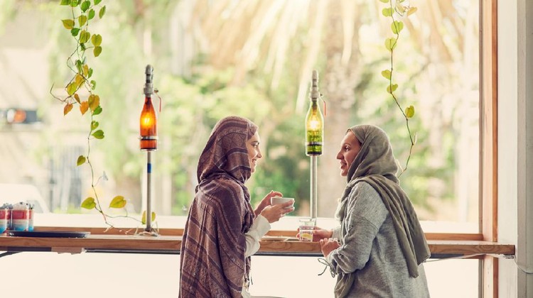 Shot of two women chatting over coffee in a cafe