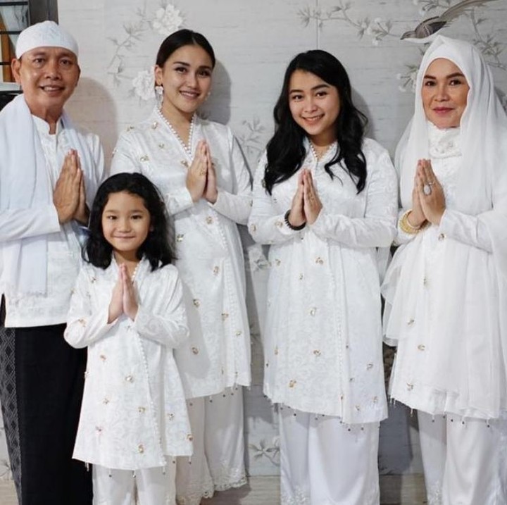 <p>Begini OOTD Idul Adha Ayu Ting Ting saat mengenakan baju muslim putih untuk tampil kompak dengan anak dan keluarga. Baju muslim Ayu Ting Ting semakin semarak dengan tambahan detail pom-pom kecil dan beads pada atasannya. Cocok buat Bunda yang lebih senang mengenakan setelan celana dibanding gamis pada perayaan yang Islami. (Foto: Instagram)</p>