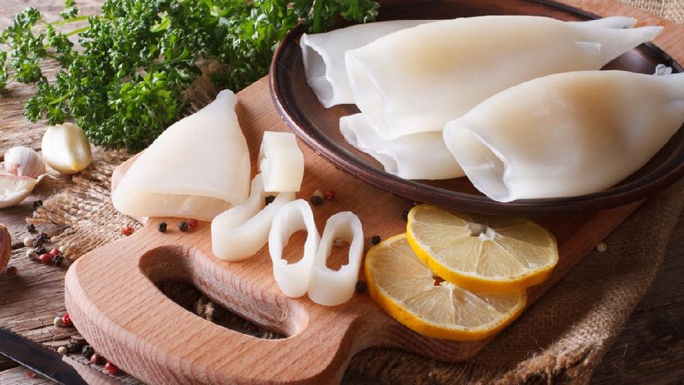 Ilustrasi cumi Sliced raw squid with ingredients on the kitchen board closeup. Horizontal