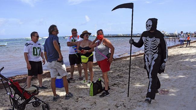Walau dilarang masuk, penduduk lokal dan turis melompati pagar untuk menyelinap ke dalam pantai-pantai di Puerto Morelos, Meksiko.