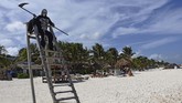 FOTO: Santai di Pantai bersama 'Malaikat Pencabut Nyawa' Pria berpakaian Santa Muerte berjalan-jalan di sebuah pantai di Meksiko demi mengingatkan pengunjung bahwa jumlah kematian COVID-19 bukan sekadar angka.