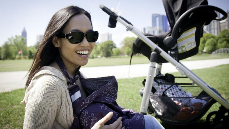 Young Mother breastfeeding her Baby in a Park. Chinese / Asian ethnicity. Photo taken in Piedmont Park, Atlanta, Georgia, USA.