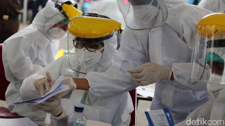 Petugas kesehatan menegambil sample darah warga yang mengikuti rapid test di Depan Kejaksaan Agung, Jakarta, Kamis (6/7/2020). Kejaksaan Agung menggelar tes cepat massal. Tes diikuti para pengendara ataupun pejalan kaki yang melintas kawasan tersebut dalam upaya pencegahan covid-19.