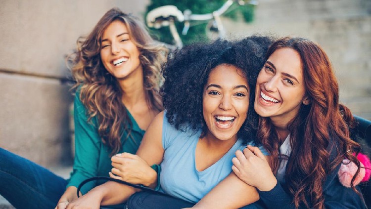 Small multi-ethnic group of beautiful young women laughing outdoors