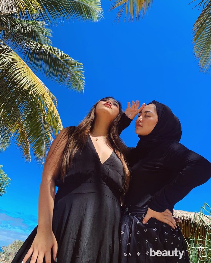 Pose di bawah terik matahari berlatar rimbunnya pohon kelapa, Rachel Vennya dan sepupunya, Chelsea kompak pakai outfit serba hitam. (Foto: instagram.com/rachelvennya/)