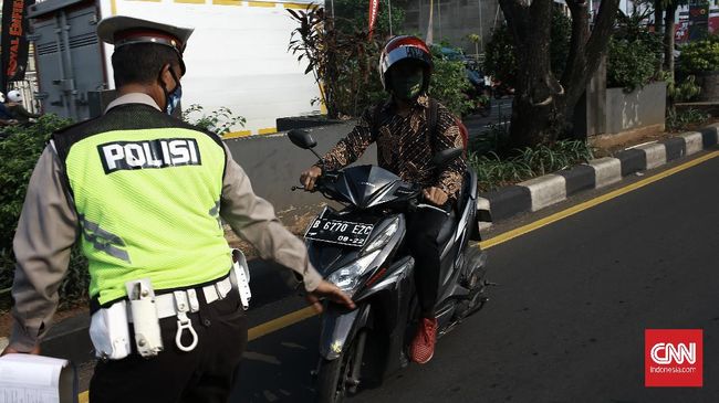 Warga Riau, Indra Putra, merusak sepeda motornya sendiri dengan menggunakan batu besar saat hendak ditilang petugas Polantas.