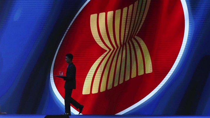 A steward carries a glass of water as he walks past the ASEAN logo during the ASEAN Business and Investment Summit (ABIS), a parallel event to the ASEAN summit in Nonthaburi, Thailand, Saturday, Nov. 2, 2019. (AP Photo/Aijaz Rahi)