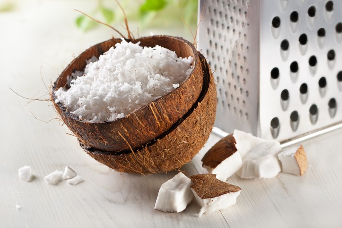 Cracked  coconut and flakes on rustic wooden table background
