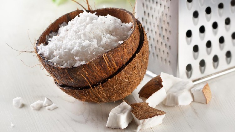Ilustrasi kelapa parut Cracked coconut and flakes on rustic wooden table background