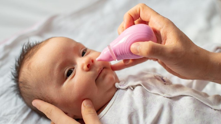 mother using baby nasal aspirator mucus nose suction