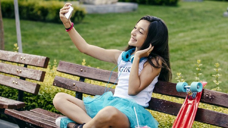 selfie Beautiful teenage girl making selfie and listening music with headphones