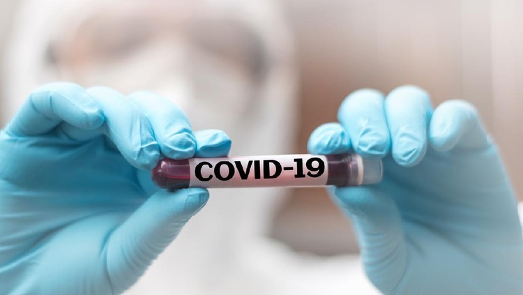 COVID-19 named by WHO for Novel coronavirus NCP concept. Doctor or lab technician in PPE suit holding blood sample with novel (new) coronavirus  in Wuhan, Hubei Province, China, medical and healthcare