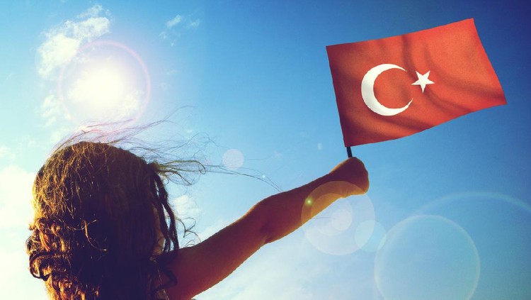 Little girl waving Turkish flag on sunny beautiful day