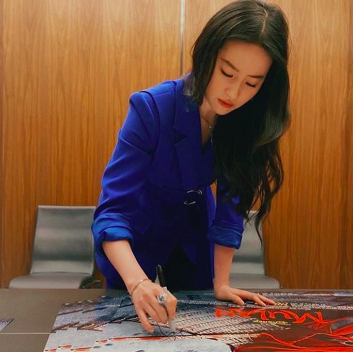 <p>Tak perlu make up tebal, Liu Yifei kerap tampil dengan riasan wajah yang sederhana, seperti saat menandatangani poster Film Mulan ini. (Foto: Instagram @yifei_cc)</p>