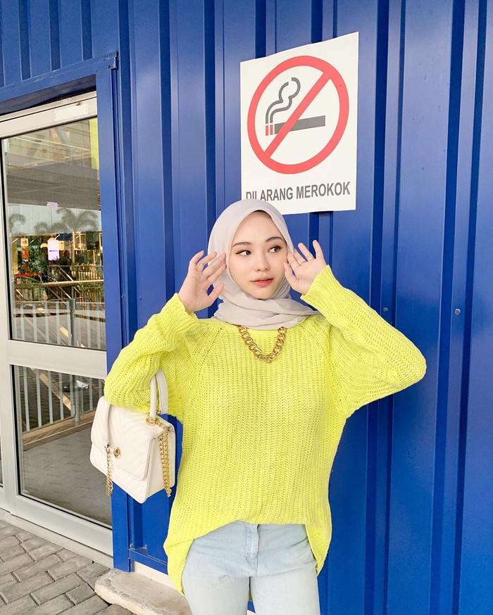 Kalau potret berikut ini memang terkesan masing ABG ya. Mengenakan atasan bahan rajut warna kuning , bawahan jeans dan hijab polos membuat Adira terlihat simpel dan kekinian. Tidak lupa, ia bergaya seperti sedang membenarkan hijab sehingga telihat lebih cute. (Foto: instagram.com/adirasalahudi)