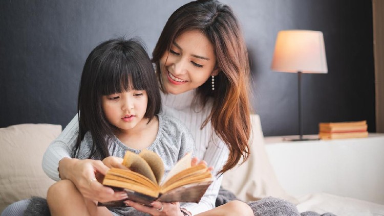Ilustrasi baca dongeng Happy Asian family mother and daughter on bed in bedroom say good night before sleep