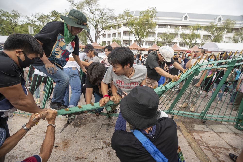Pro-democracy demonstrators force themselves into the Sanam Luang field, a popular location for political protests, in Bangkok, Thailand, Saturday, Sept. 19, 2020. Protesters gathered Saturday in Bangkok for what was expected to be the biggest rally yet in an ongoing campaign calling for a new election and democratic reforms. (AP Photo/Sakchai Lalit)