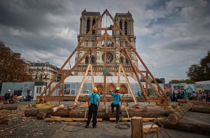 PARIS, FRANCE - SEPTEMBER 19: A member of the Charpentiers sans Frontièrs (Carpenters without Borders) works on the reconstruction of one of the missing timber frames of Notre-Dame Cathedral that was destroyed by the fire in front of the Cathedral on September 19, 2020 in Paris, France. Part of the 37th edition of the European Heritage Days, the iconic Parisian landmark aims at informing the public of the reconstruction plans related to the April 15, 2019 fire and aims to imporve the public's knowledge of Notre-Dame's architecture and history. The extensive damage to the roof and spire of the 13th-century Notre Dame de Paris cathedral have proven reconstruction process to be much more complex than many anticipated. (Photo by Kiran Ridley/Getty Images)