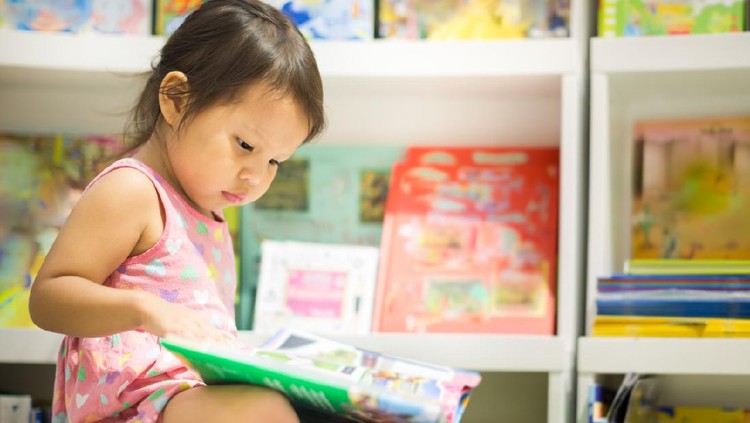 A smart little girl reading books in the bookstore