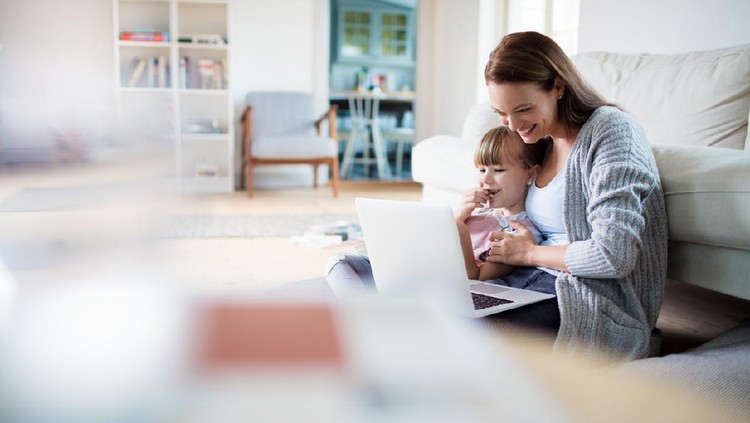 Close up of a mother and daughter using a laptop at home