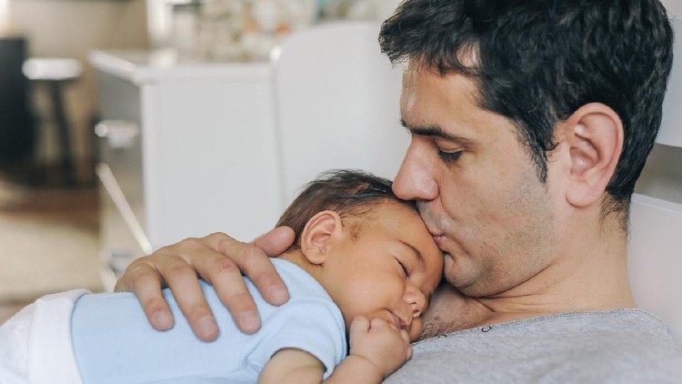 Father enjoying at home with his newborn baby boy