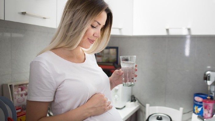 Pregnant woman drinking water in the morning