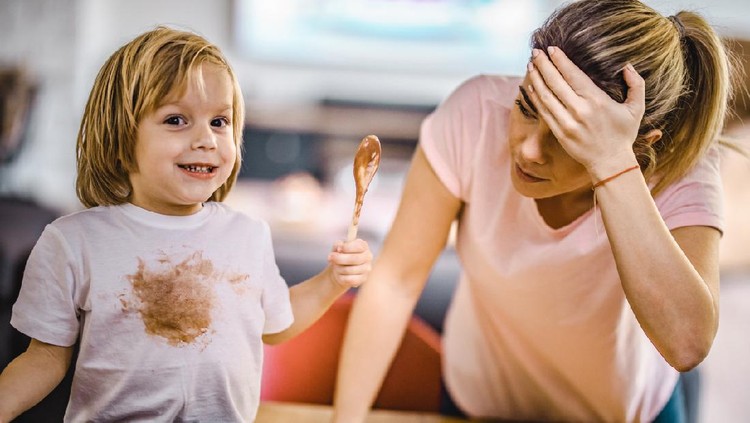 Small boy stained himself with chocolate while his mother is in disbelief.