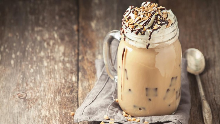 Coffee with ice, cream and chocolate on wooden background