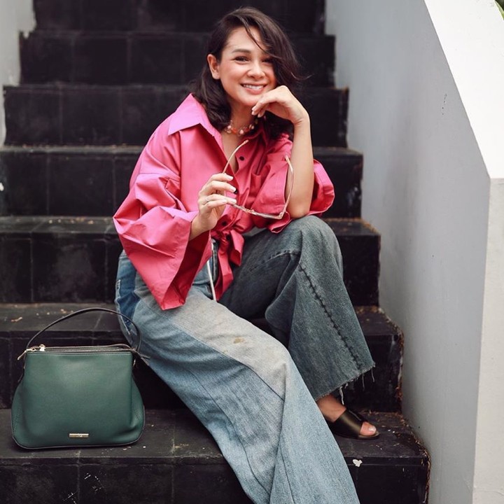 Lihat gaya Andien Aisyah yang mengenakan kemeja crop top warna shocking pink. Padukan sesekali dengan celana jeans palazzo yang atraktif. Super stylish dan epik, Bunda. (Instagram @andienaisyah)