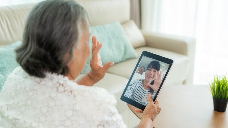Asian elderly woman virtual happy hour meeting and talking online together with her daughter in video conference with tablet for a online meeting in video call for social distancing.