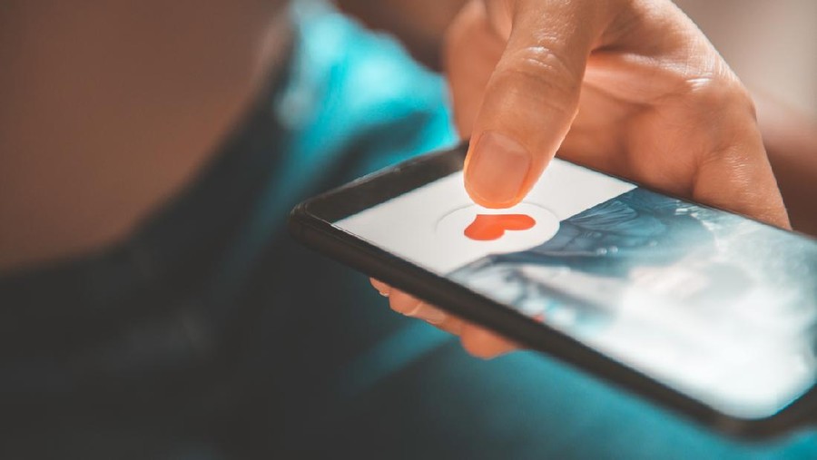 Aplikasi kencan Finger of woman pushing heart icon on screen in mobile smartphone application. Online dating app, valentine's day concept.