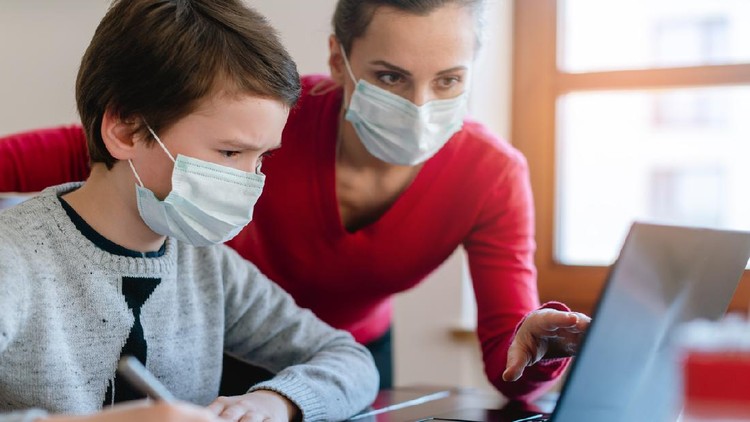 Mother and son in video chat with school teacher wearing masks