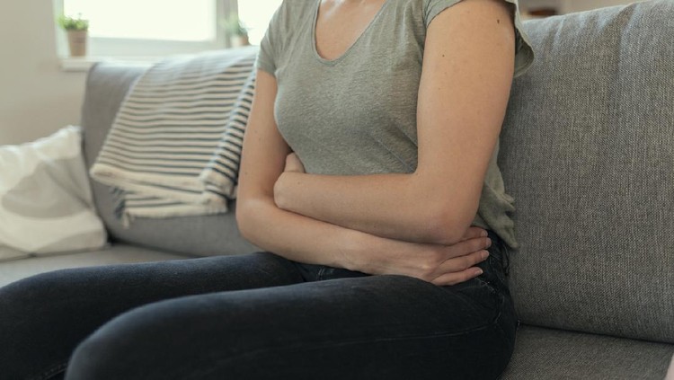 Woman With Abdomen Problems in Bed, She Use Hands to Massage Painful Place. People with diarrhea problem concept. Woman with menstrual pain