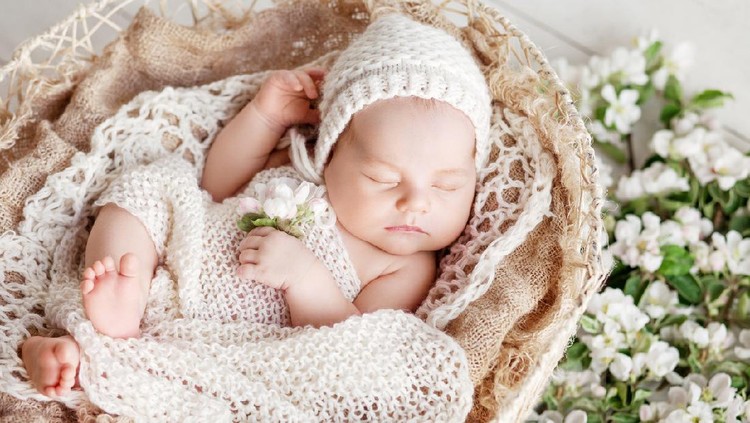 bayi perempuan Sweet newborn baby sleeps in a basket. Beautiful newborn boy with flowers