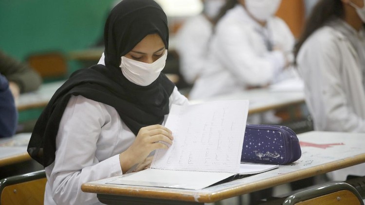 13-year-old student Chaimaa Talaaloute wears a face mask in the classroom at Mansour Eddahbi College in the Derb El Kabir district of the AL Fida prefecture in Casablanca, Morocco, on Monday, Oct. 5, 2020. Today it is the start of the school year in Casablanca, with a delayed start due to the COVID-19 pandemic. (AP Photo/Abdeljalil Bounhar)